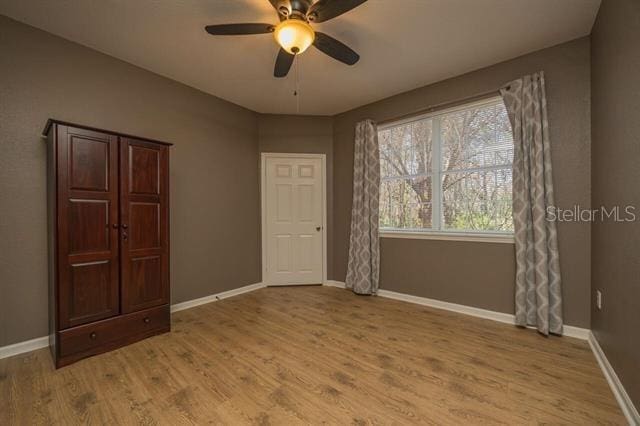 unfurnished room featuring ceiling fan and light wood-type flooring