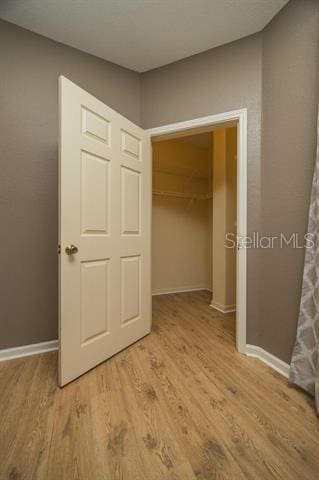 unfurnished bedroom featuring light hardwood / wood-style floors and a closet