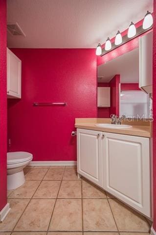 bathroom with vanity, toilet, and tile patterned flooring