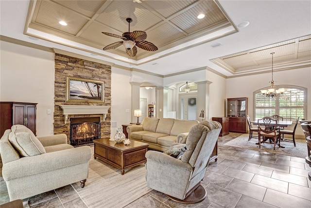 tiled living room with crown molding, wooden ceiling, a raised ceiling, and ornate columns