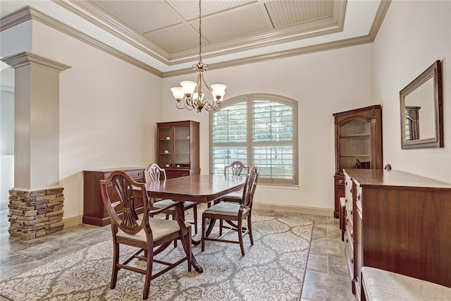 dining area with ornate columns, crown molding, a notable chandelier, and a tray ceiling