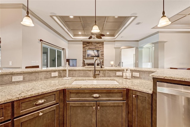 kitchen featuring stainless steel dishwasher, ornamental molding, decorative light fixtures, and sink