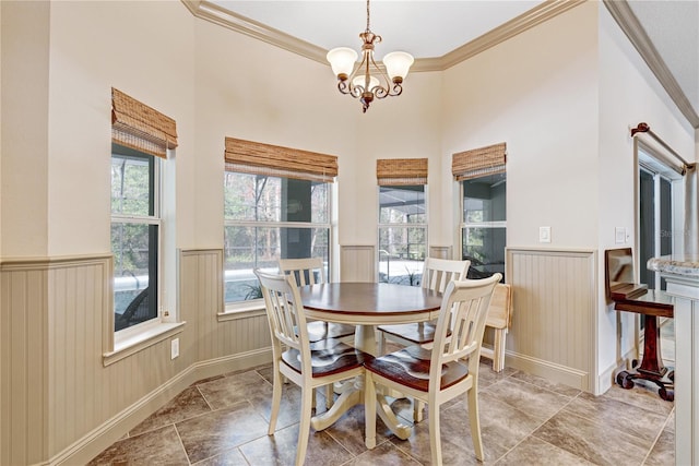 dining space with a high ceiling, ornamental molding, and a notable chandelier