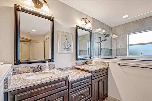 bathroom featuring vanity and tiled shower