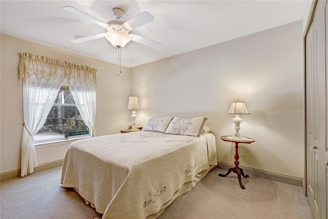 carpeted bedroom with ceiling fan and a closet