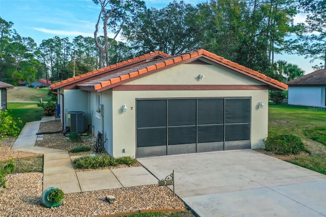 garage featuring a lawn and central air condition unit