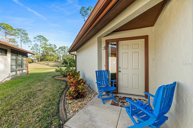 doorway to property featuring a lawn