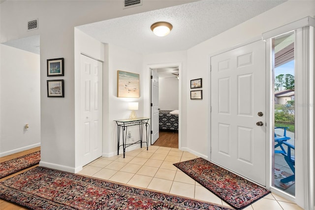 entrance foyer featuring light tile patterned floors and a textured ceiling