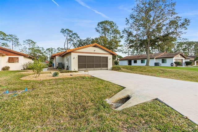 view of front of property with a garage, central AC, and a front yard