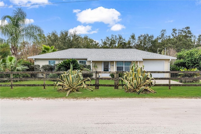 ranch-style home with a garage and a front lawn