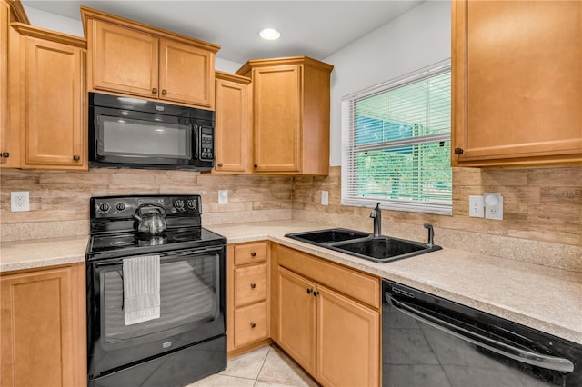 kitchen featuring tasteful backsplash, light tile patterned flooring, sink, and black appliances