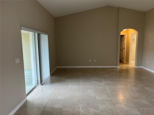 unfurnished room with lofted ceiling and light tile patterned floors