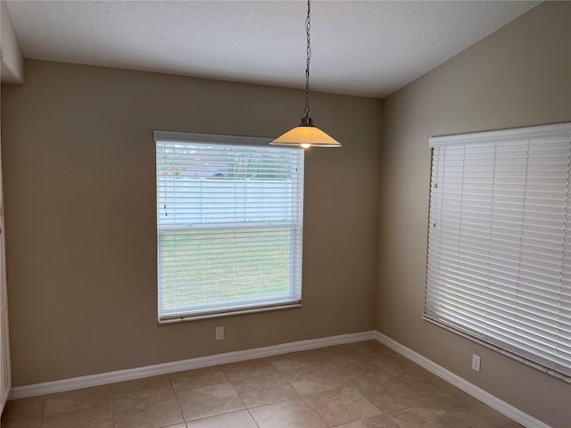 spare room featuring lofted ceiling and a textured ceiling