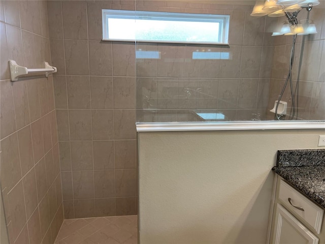 bathroom featuring vanity, a wealth of natural light, and tiled shower