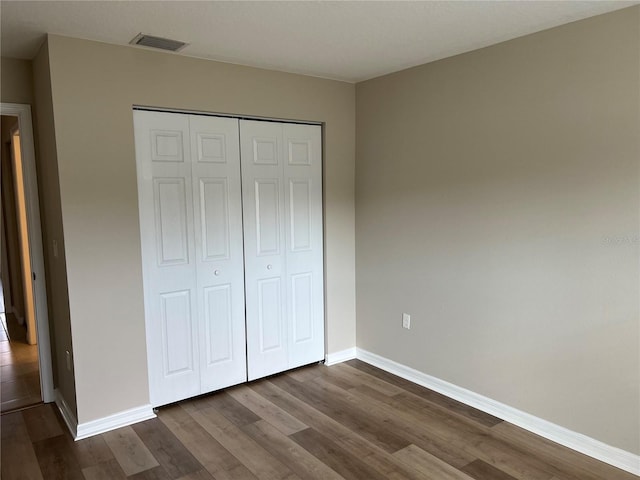 unfurnished bedroom with hardwood / wood-style flooring and a closet