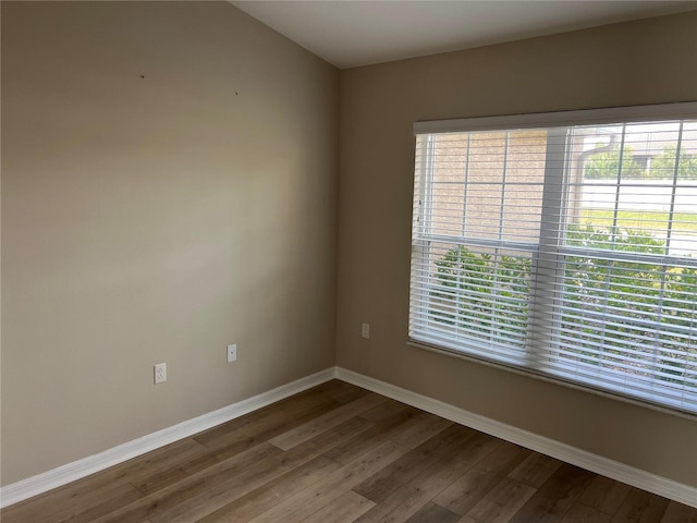 unfurnished room with hardwood / wood-style flooring and a healthy amount of sunlight