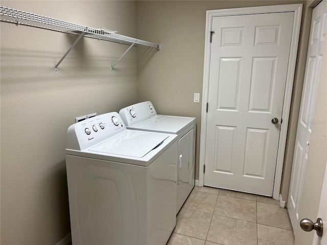 laundry room with light tile patterned floors and washing machine and dryer