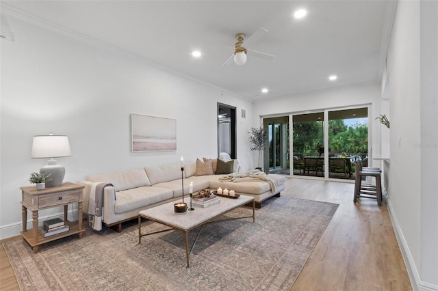 living room with crown molding, light hardwood / wood-style flooring, and ceiling fan