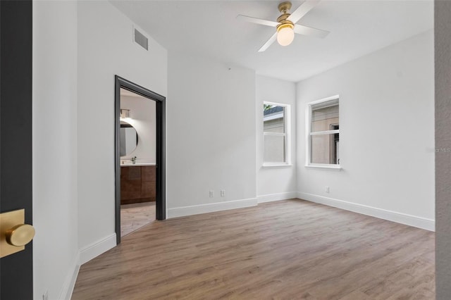 spare room with ceiling fan and light wood-type flooring