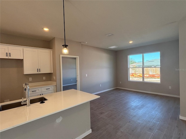 kitchen featuring pendant lighting, sink, dark hardwood / wood-style flooring, and white cabinets