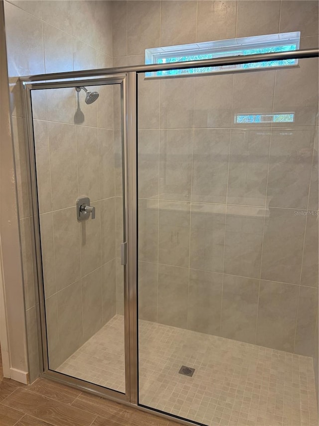 bathroom featuring a shower with shower door