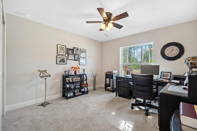 carpeted office space featuring ceiling fan