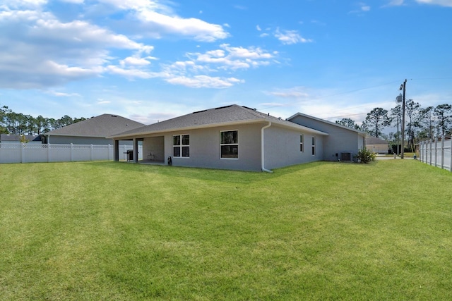 back of house with a yard and central air condition unit