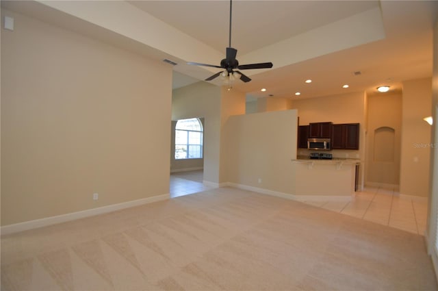 unfurnished living room with light carpet and ceiling fan