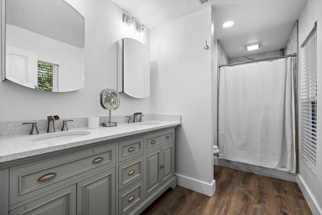 15 Cloverdale Ct S, Palm Coast, FL 32137 - full bathroom with a textured ceiling, double vanity, wood finished floors, toilet, and baseboards