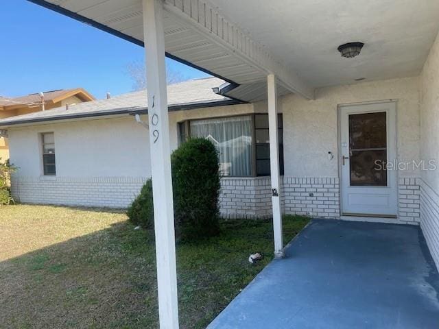 doorway to property with a lawn