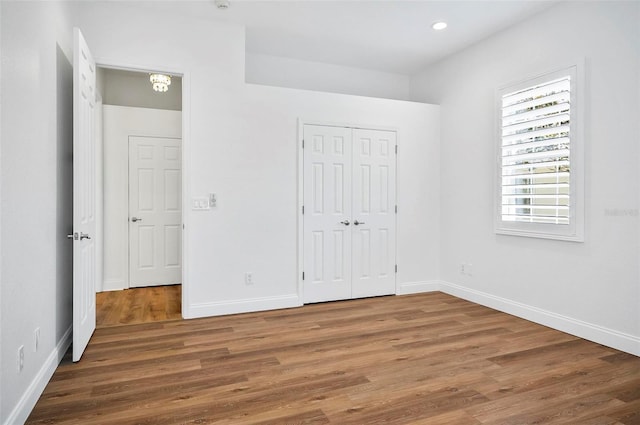 unfurnished bedroom with dark wood-type flooring and a closet