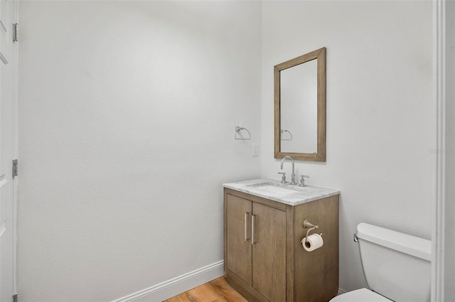 bathroom featuring hardwood / wood-style flooring, vanity, and toilet