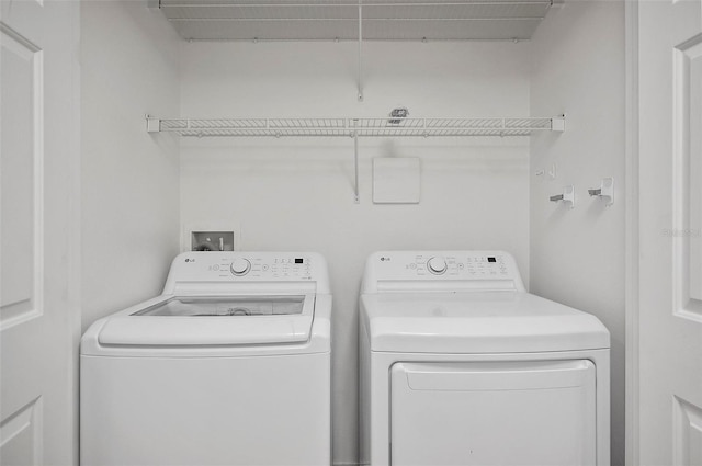 clothes washing area with washing machine and dryer