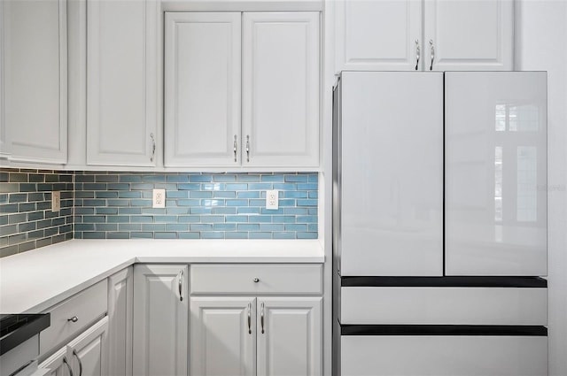 kitchen featuring decorative backsplash, white cabinets, and white fridge