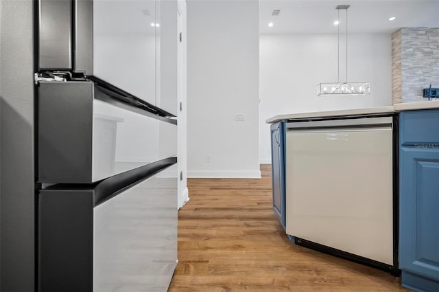 kitchen with blue cabinetry, decorative light fixtures, dishwasher, and light hardwood / wood-style floors