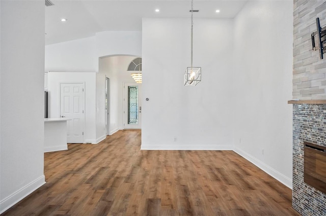 unfurnished dining area with high vaulted ceiling and hardwood / wood-style floors