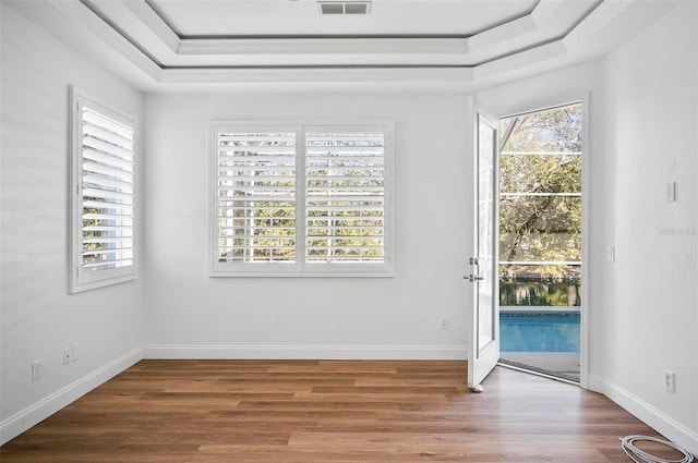 entryway with hardwood / wood-style floors and a tray ceiling