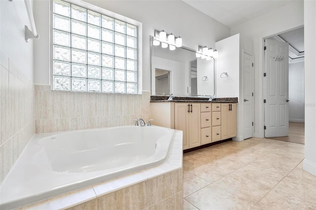 bathroom featuring vanity, tiled tub, and tile patterned floors