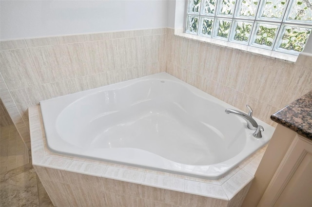 bathroom featuring vanity and tiled bath