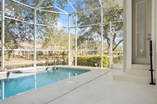 view of swimming pool with a patio, a water view, and glass enclosure