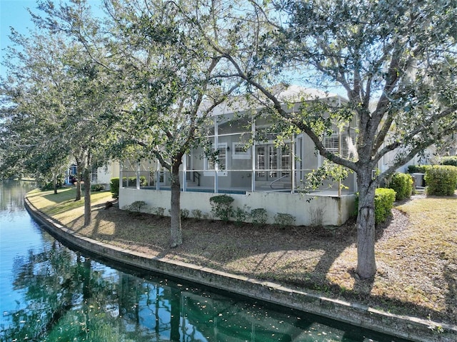 rear view of property featuring a water view and glass enclosure