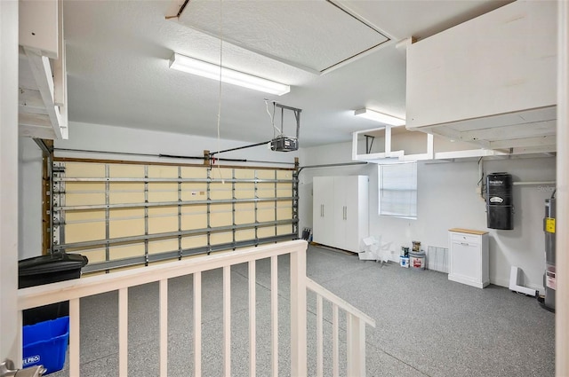 garage with water heater and a garage door opener