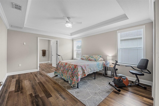 bedroom featuring a raised ceiling, ornamental molding, a textured ceiling, and dark hardwood / wood-style flooring