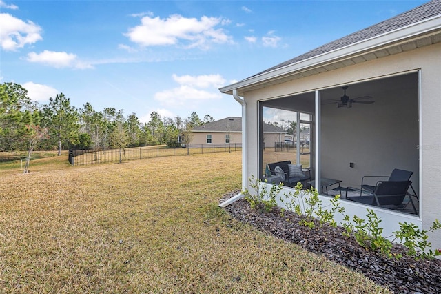 view of yard with ceiling fan and a sunroom