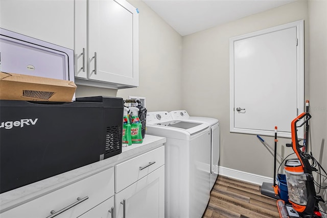 laundry room with dark hardwood / wood-style flooring, cabinets, and washer and dryer