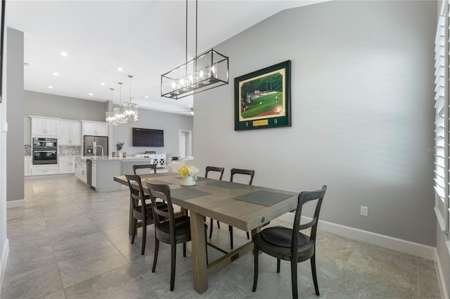 dining space featuring sink and vaulted ceiling