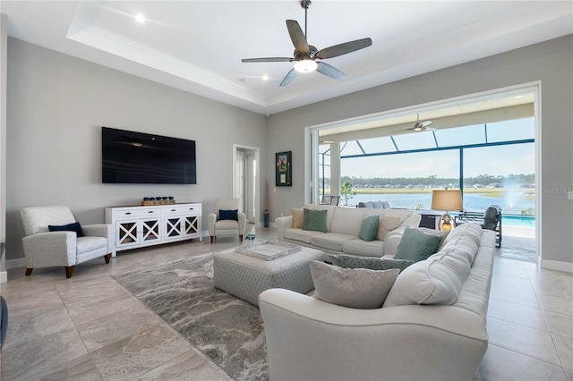 living room with ceiling fan and a tray ceiling