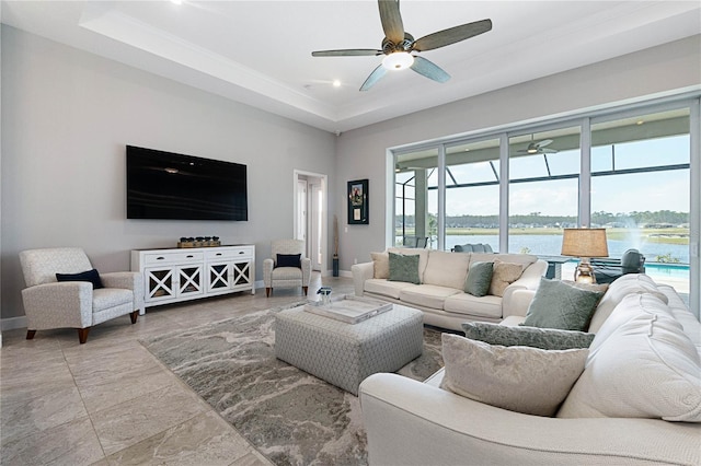 living room with ceiling fan and a tray ceiling