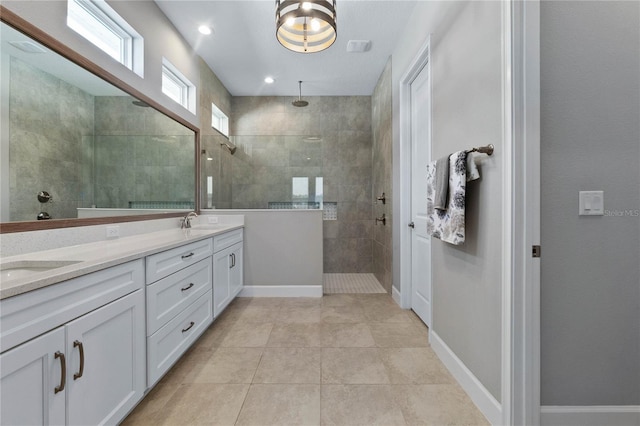 bathroom featuring tile patterned flooring, vanity, and tiled shower