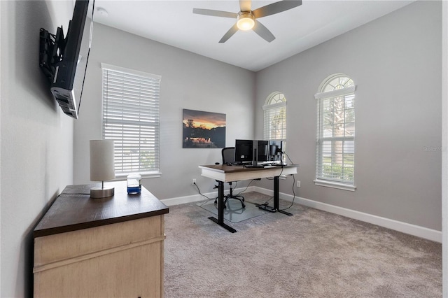 carpeted office space featuring ceiling fan